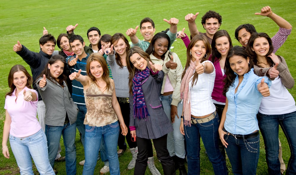 happy group of friends with thumbs up outdoors in a park